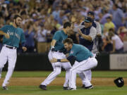 Seattle Mariners' Mike Zunino, center, is greeted by teammates after he hit a walk-off RBI single to give the Mariners a 5-4 win in the 10th inning against the Chicago Cubs on Friday.