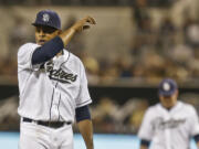 San Diego Padres starting pitcher Edinson Volquez wipes this face as he battles in the first inning against the Chicago Cubs where he allowed six runs in the baseball game on Friday, Aug. 23, 2013, in San Diego.