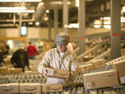 An Amazon.com employee grabs a box off a conveyor belt in 2008 at the retailer's Fernley, Nev., warehouse.