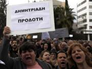 Employees of Bank of Cyprus shout slogans and wave a banner reading in Greek &quot;Demitriades Traitor&quot; referring to Cyprus Central Bank Governor Panicos Demetriades, during a protest at Cyprus central bank in capital Nicosia, Cyprus, on Tuesday.