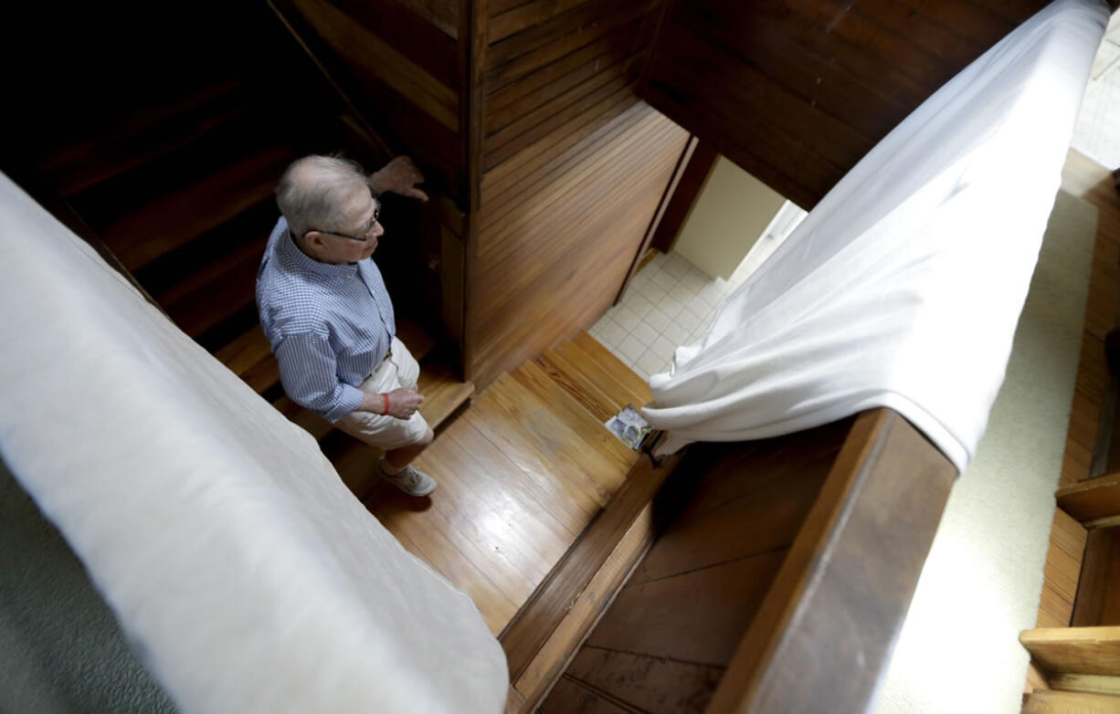 In this Friday, May 31, 2013 photo, Robert Post, 85, walks down the stairs in his home, in Mantoloking, N.J., which was flooded during Superstorm Sandy last year. Post has a pacemaker that needs to be checked once a month by phone, but the  phone company refuses to restore the area's landlines after they were damaged by the storm. Verizon doesnit want to replace washed-away lines and waterlogged underground cables because phone lines are outdated, it says. Meanwhile, the company is offering a wireless device that can be plugged into home phones for service, but the system does not work with pacemakers or fax machines.