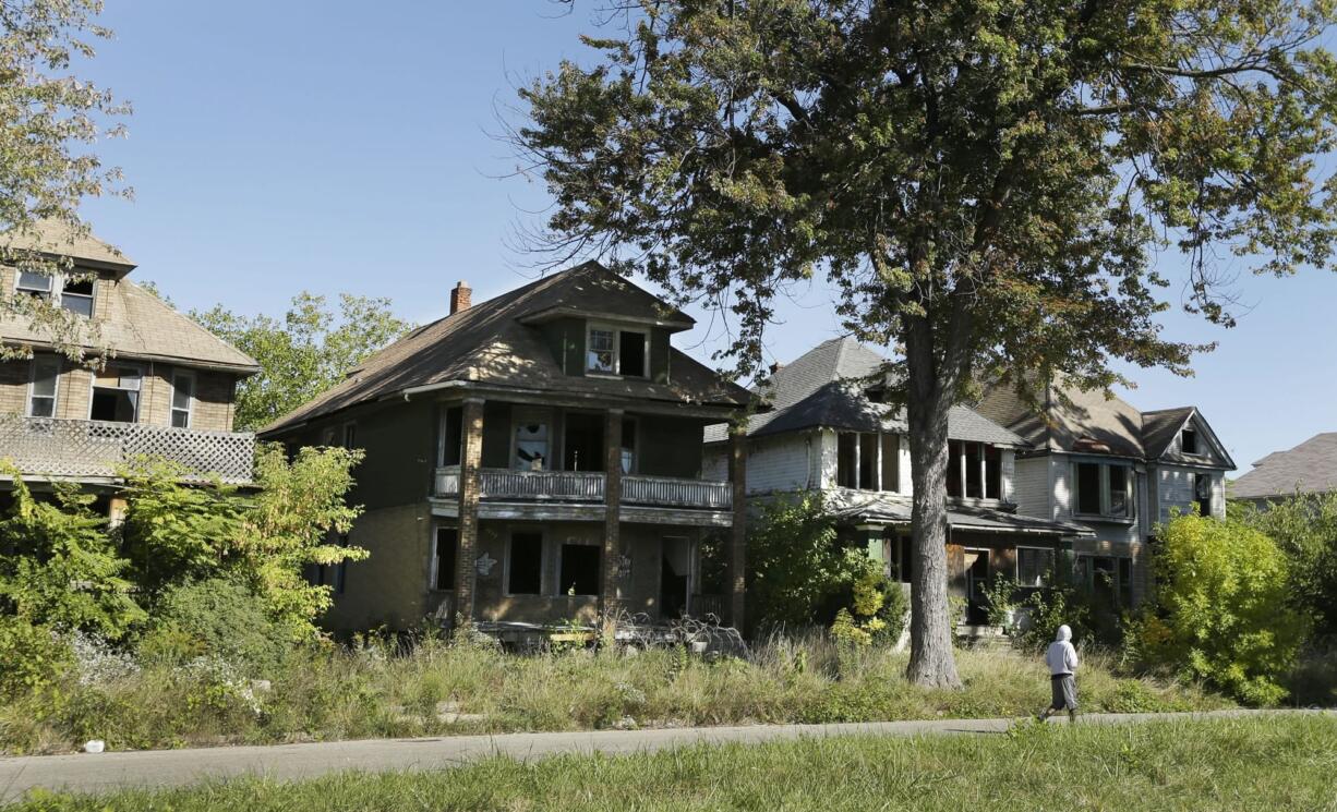 A young man walks in front of a row of abandoned houses in Detroit on Thursday.