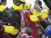 Tommy Aldin, 10, center in red, reacts after being hit in the head with hard candies being dumped by a conveyer truck during last year's Dozer Days.