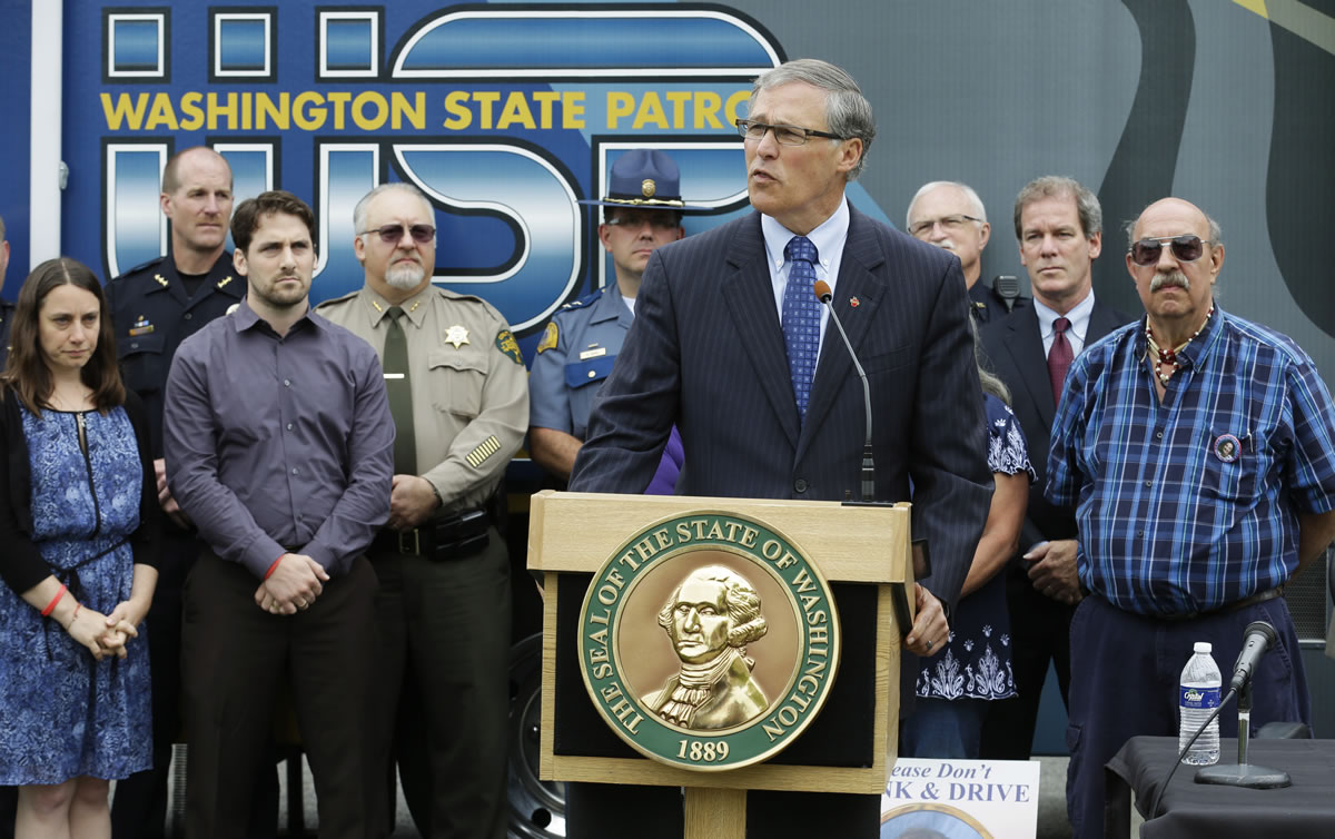 Washington Gov. Jay Inslee, center, speaks Thursday at a bill-signing ceremony in Tacoma.