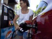 Suzanne Meredith of Walpole, Mass., fuels her car at a Gulf station in Brookline, Mass.