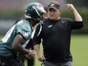 Philadelphia Eagles coach Chip Kelly, right, speaks with Ifeanyi Momah at the NFL football team's training camp in Philadelphia, Tuesday, Aug. 13, 2013.