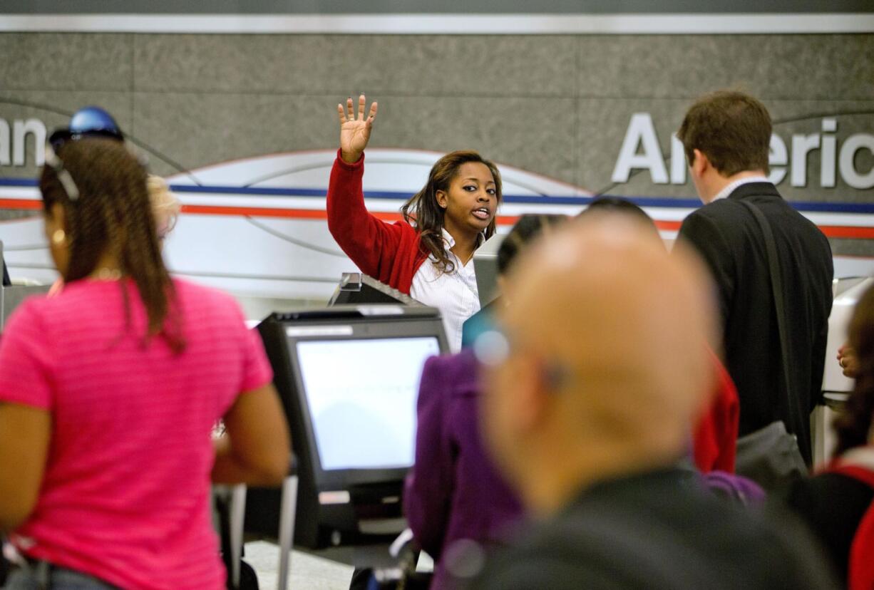 An American Airlines ticket agent talks assists passengers checking in at Hartsfield-Jackson airport in Atlanta. AMR Corp.