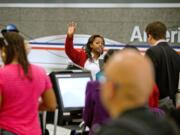 An American Airlines ticket agent talks assists passengers checking in at Hartsfield-Jackson airport in Atlanta. AMR Corp.