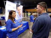 Registered nurse Salanda Bowman, left, talks with part-time Kentucky Wesleyan College student Jason Ward, of Whitesville, about job openings at the Owensboro Health Regional Hospital during a Regional Career and Job Fair in the Owensboro Sports Center in Owensboro, Ky.