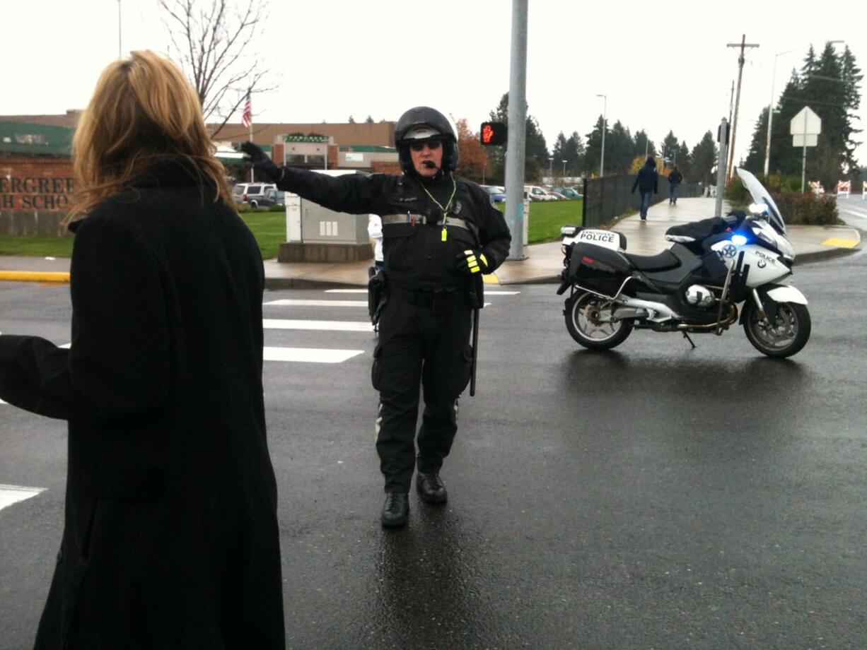 An officer directs traffic at Evergreen High School.