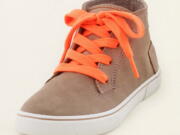 This product image released by The Children's Place shows a camel sneaker with orange neon laces. Unlike so many looks that trickled down from the designer runways into mass retailers and into teenagers' closets, the almost electrifying shades of pink, green, yellow and orange have been hanging out in high school hallways for a while. And they're back again for the new school year.