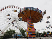 Visitors ride on the Ferris Wheel and Wave Swinger at Chicago's nearly century-old Navy Pier.