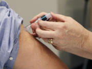 A flu shot is administered in Jackson, Miss.