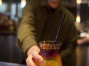 Bartender James Smith delivers a $5 Mai Tai during happy hour at Roy's restaurant in San Francisco.