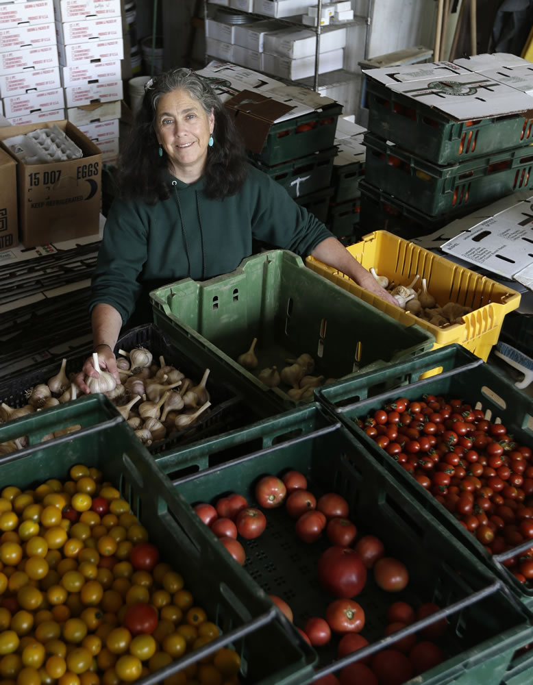 Justine Denison poses with fresh produce at Denison Farm on Aug. 12 in Schaghticoke, N.Y.