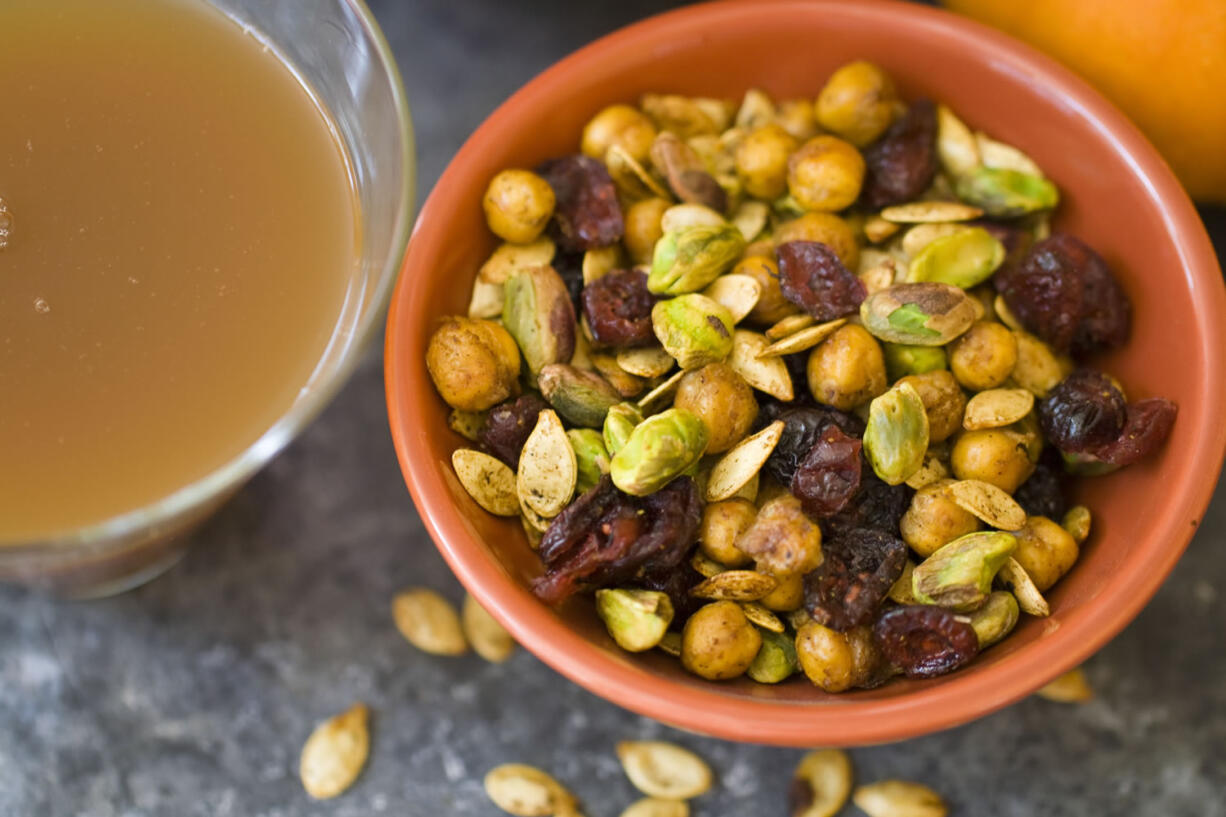 A healthy Halloween snack mix includes chickpeas, pumpkin seeds, dried cranberries and nuts.