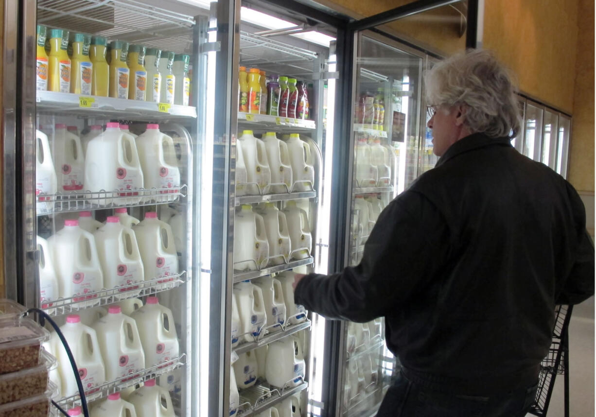 Jim Mitchell selects a gallon of milk at a Milwaukee grocery store.