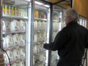 Jim Mitchell selects a gallon of milk at a Milwaukee grocery store.