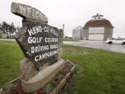 A sign for the Hend-Co-Hills Golf Course sits near a storage barn on a farm in Biggsville, Ill.