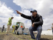 Jorge Heraud, CEO of Blue River Technology, center, explains how the lettuce bot works as software engineer Willy Pell, in green, watches in Salinas, Calif., on May 23.