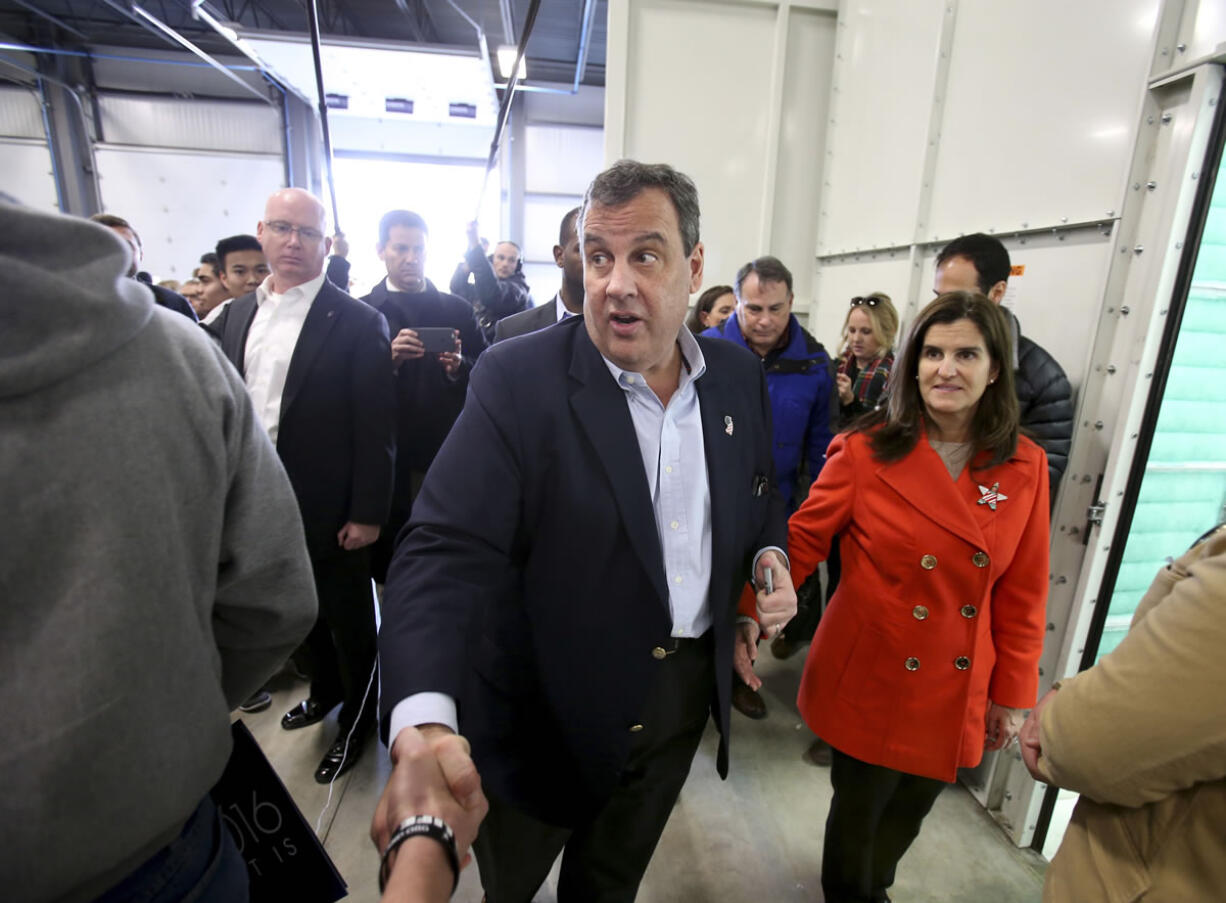 Republican presidential candidate New Jersey Gov. Chris Christie shakes hands with potential supporters as his wife Mary Pat watches during a campaign stop Saturday in Exeter, N.H.