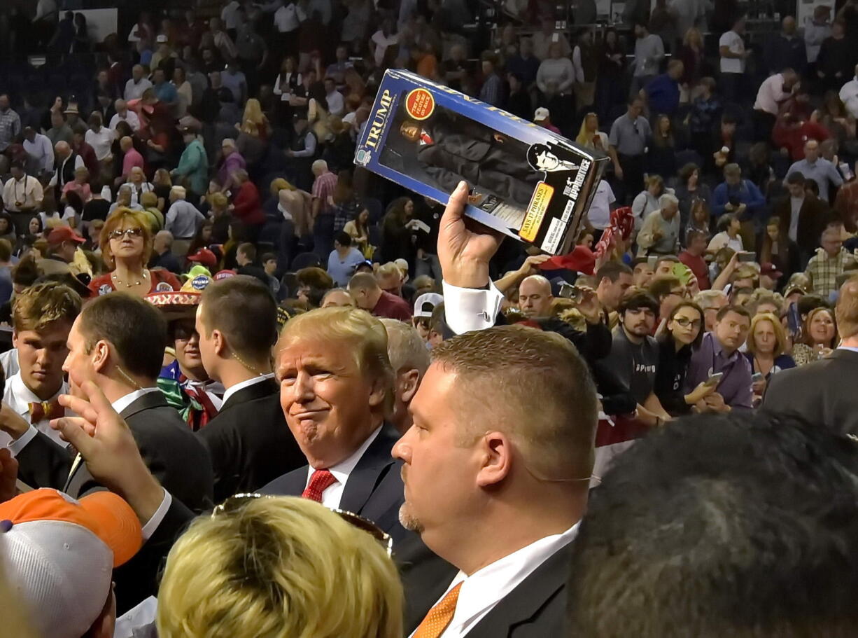 Republican presidential candidate Donald Trump holds a toy Trump doll after speaking at a town hall meeting in the Convocation Center on the University of South Carolina Aiken campus Saturday, Dec. 12, 2015, in Aiken, S.C.