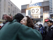 Union employee Elena Perez, right, embraces colleague Steve Williamson near a &quot;countdown clock&quot; for a strike deadline after a tentative agreement was announced Monday in Seattle.