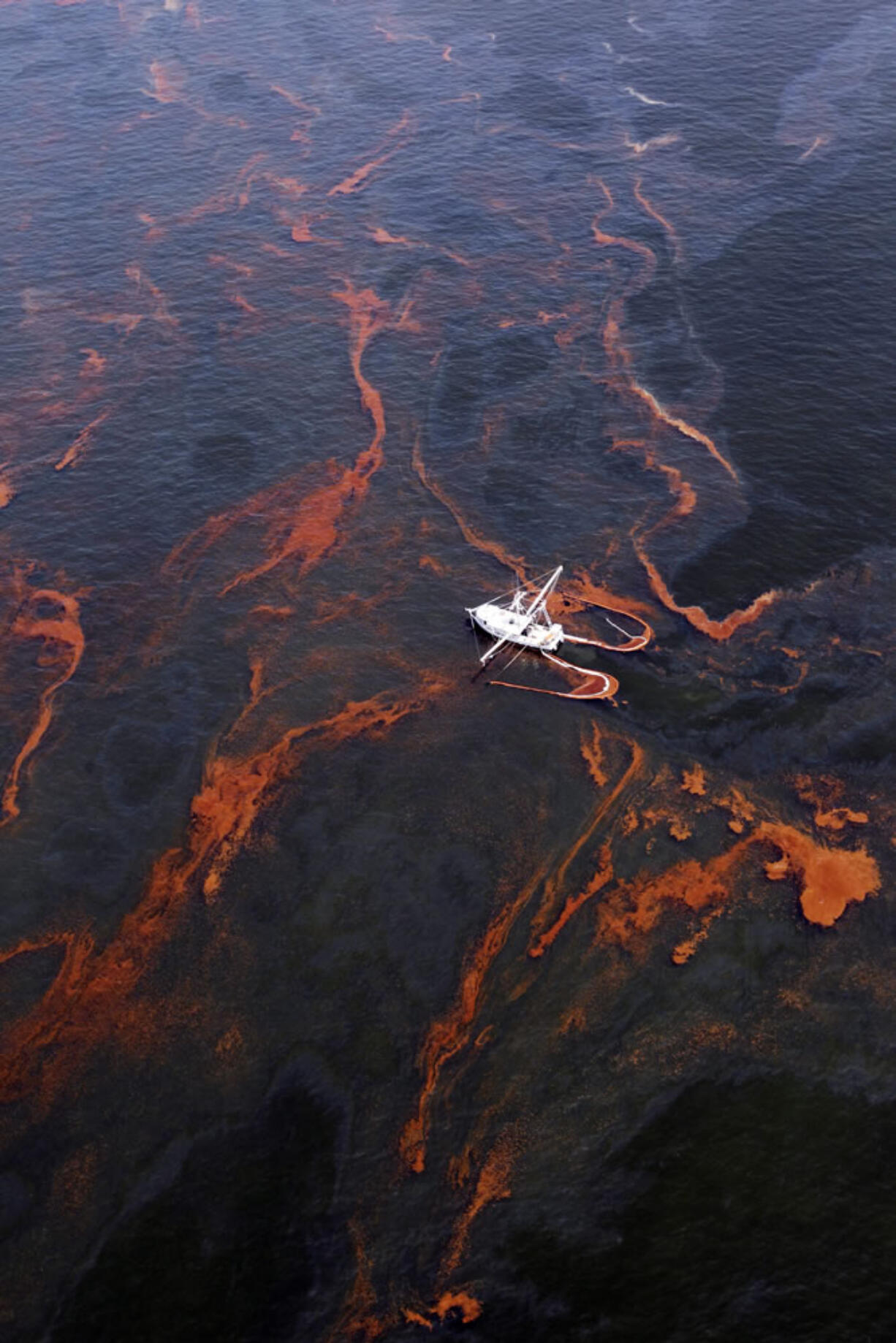 A shrimp boat is used to collect oil with booms in the waters of Chandeleur Sound, La., in May 2010.