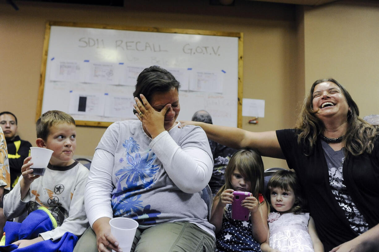 Nikki Lindquist, center, cries tears of joy as she is comforted by her sister, Tiffany Koch, after their father, Bernie Herpin, was named the victor in the election to recall Colorado State Sen.