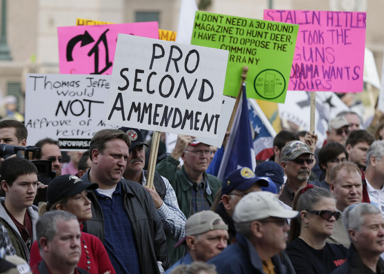 Gun rights supporters hold signs Saturday at a Guns Across America rally at the Texas state capitol in Austin, Texas. Thousands of gun advocates have gathered peacefully at state capitals across the U.S.