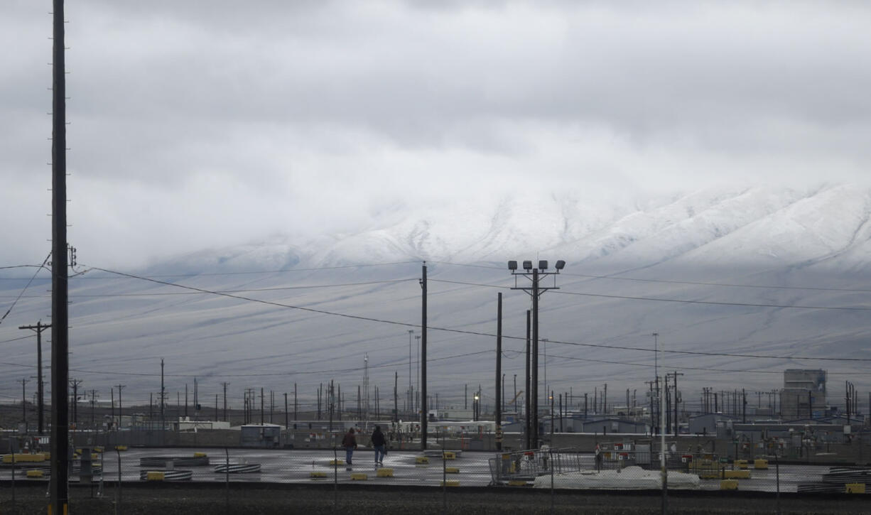 Workers walk on a covered area where tanks containing radioactive waste are buried at the T Tank Farm at the Hanford Nuclear Reservation near Richland.