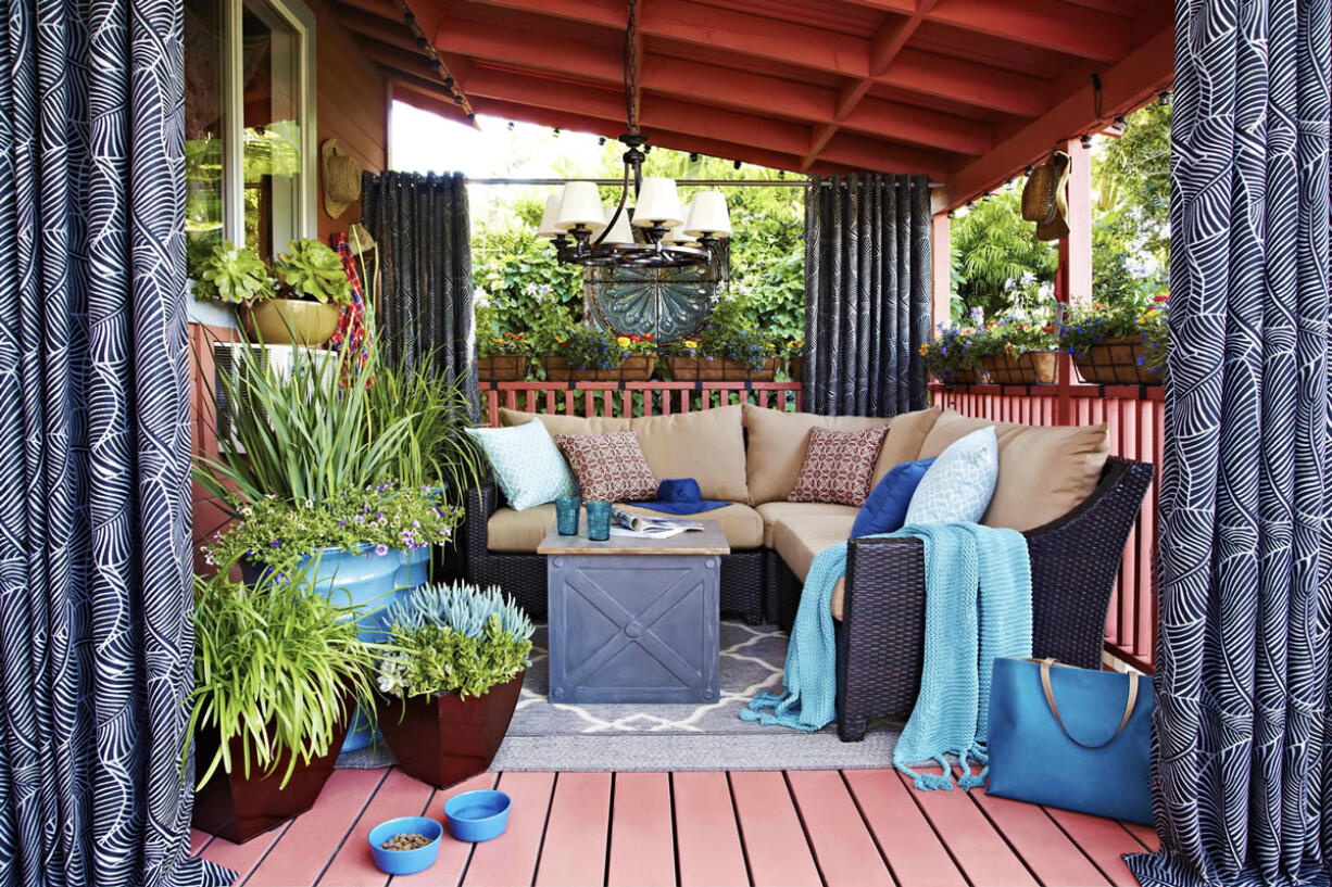 Furniture of this outdoor living room designed by Brian Patrick Flynn for Hayneedle.com is arranged around an outdoor chandelier.