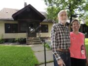 Julian Sellers and his wife Barbara stand  in front of their St. Paul, Minn., bungalow.