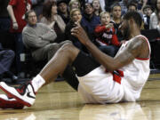 Don Ryan/The Associated Press
Blazers forward LaMarcus Aldridge grimaces after spraining his ankle on Sunday against the Hornets.