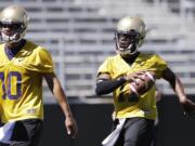 Washington quarterback Keith Price, right, and Cyler Miles runs at the team's first football practice Monday, Aug.