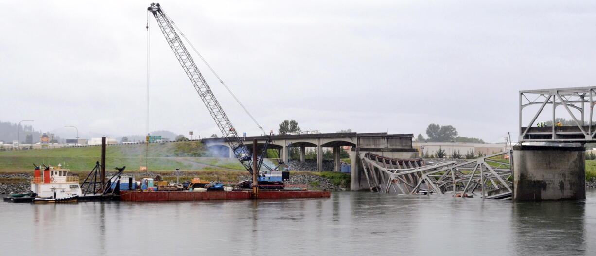 A view from the Mount Vernon side of the Skagit River shows a crane on a barge Sunday at the scene of the Interstate 5 bridge collapse in Washington.