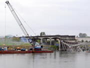 A view from the Mount Vernon side of the Skagit River shows a crane on a barge Sunday at the scene of the Interstate 5 bridge collapse in Washington.