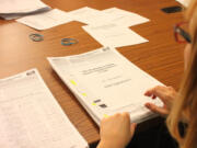 Renee Wyman, a paid signature checker, tallies pages of signatures in July at the State Elections Office.