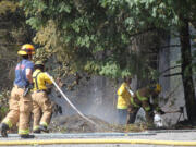 Emergency crews from three agencies work to put out a brush fire on Leadbetter Road Thursday morning.