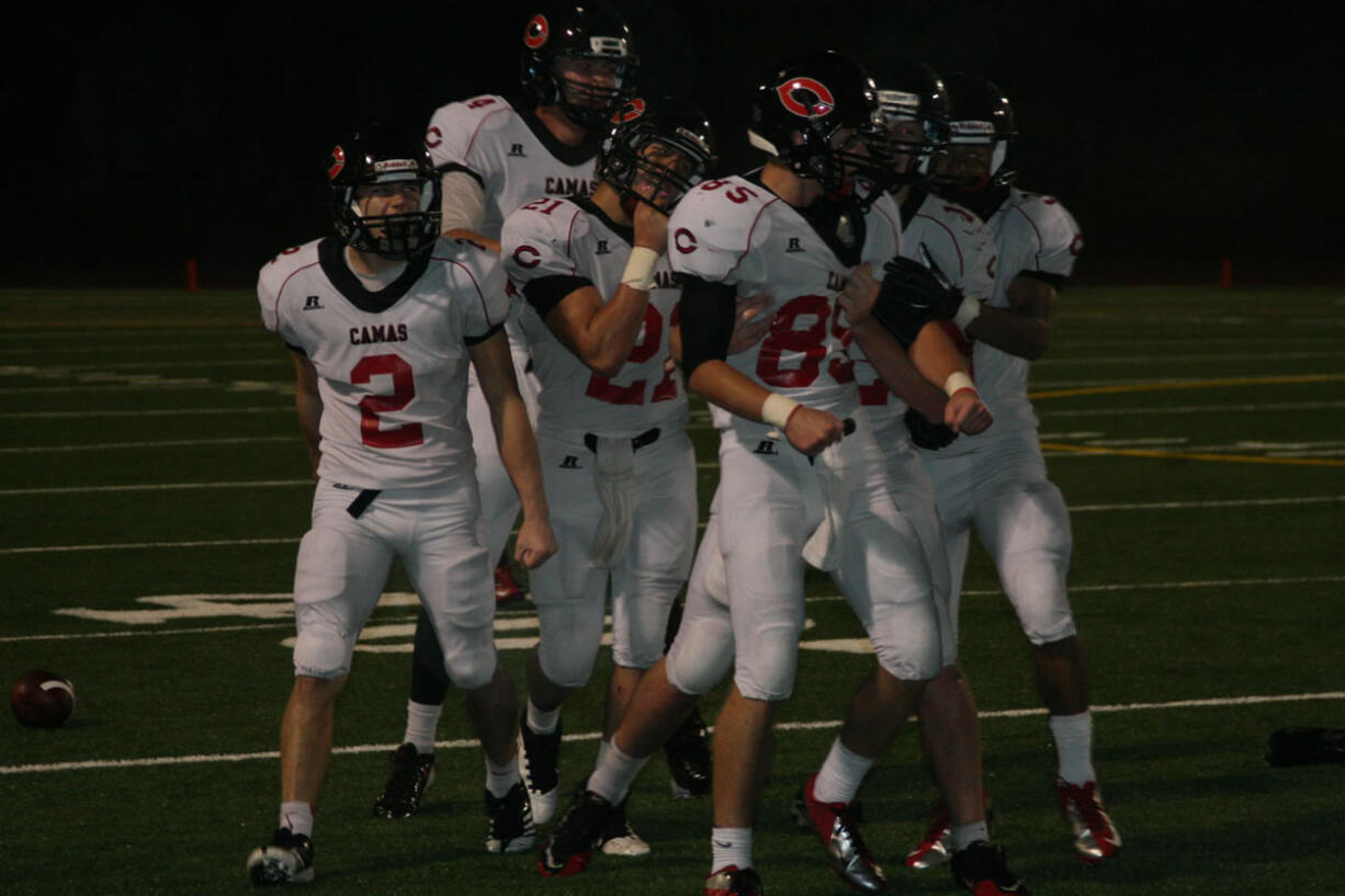 The Camas defenders celebrate with Connor Maloney (85) after he knocked the wind out of a Union receiver Friday, at McKenzie Stadium.