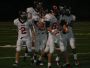 The Camas defenders celebrate with Connor Maloney (85) after he knocked the wind out of a Union receiver Friday, at McKenzie Stadium.