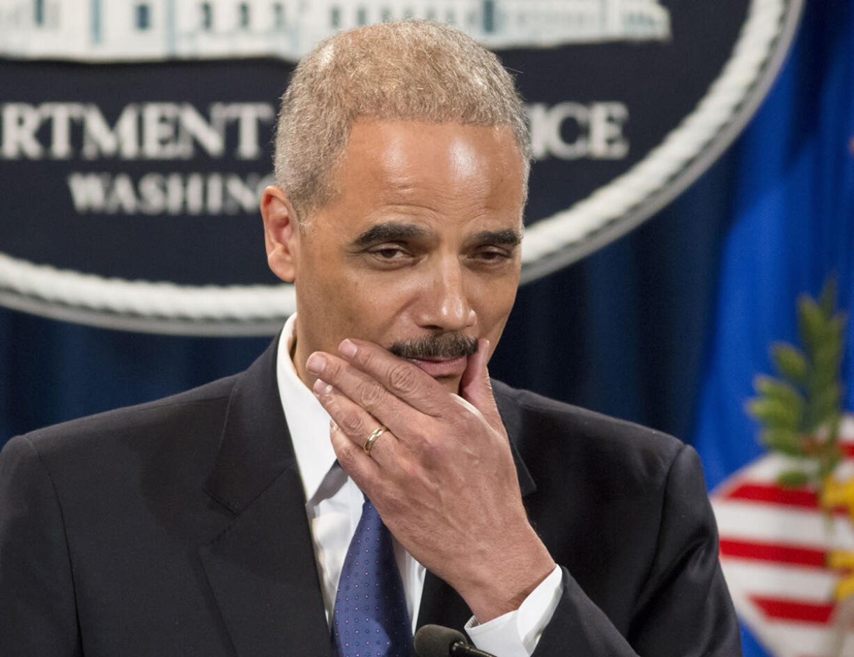 Attorney General Eric Holder pauses during a news conference at the Justice Department in Washington on Tuesday .