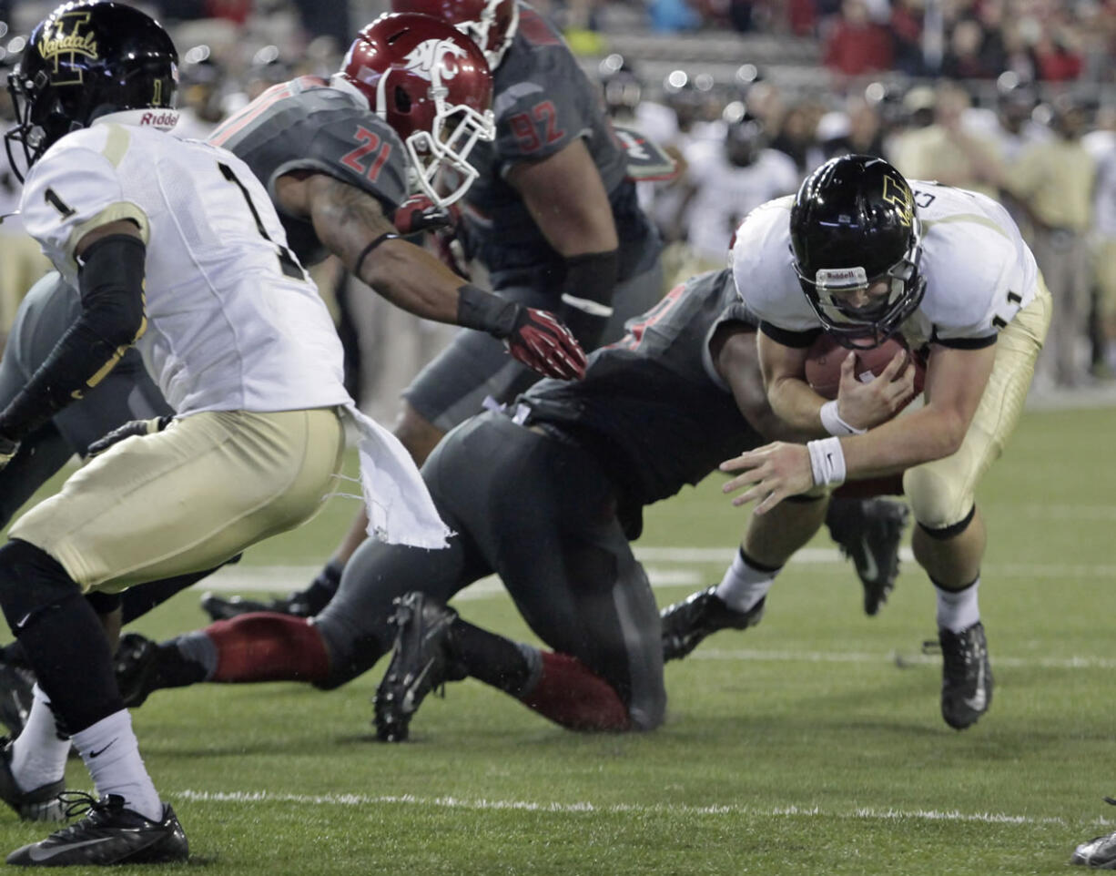 Washington State linebacker linebacker Darryl Monroe, center, on knee, tackles Idaho quarterback Chad Chalich at the 1-yard-line as linebacker Eric Oertel (21) comes in to help Saturday in Pullman.