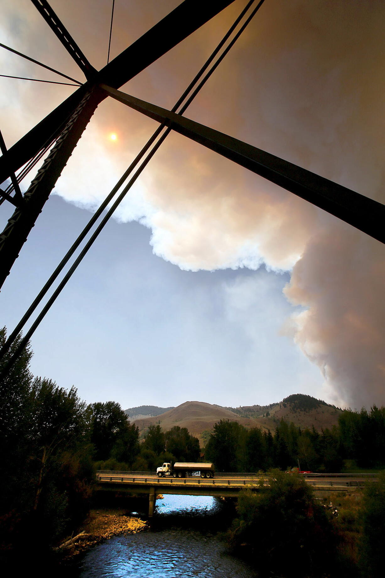A view from a bridge over the Big Wood River, as smoke rises from the 44,000-acre Beaver Creek Fire on Thursday, north of Hailey, Idaho.