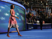 FILE - In this Tuesday, Sept. 4, 2012 file photo, first lady Michelle Obama walks onto the stage at the Democratic National Convention in Charlotte, N.C.  Obama's dress was designed by Tracy Reese. Obama has proven her fashion savvy time and time again since she was introduced to the country as first lady on Inauguration Day 2009. In the past four years she has adeptly walked the line between directional fashionista and everywoman. (AP Photo/Jae C.