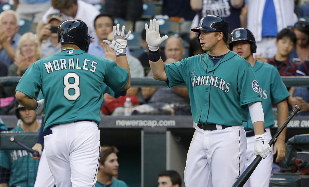 Seattle Mariners' Kendrys Morales (8) is greeted by Mariners' Justin Smoak, right, after Morales hit a home run in the fourth inning against the Cleveland Indians on Monday.