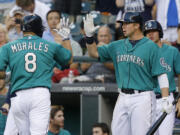 Seattle Mariners' Kendrys Morales (8) is greeted by Mariners' Justin Smoak, right, after Morales hit a home run in the fourth inning against the Cleveland Indians on Monday.