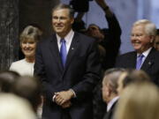 Gov. Jay Inslee, center, is escorted by Sen. Linda Evans Parlette, R-Wenatchee, left, and Rep.