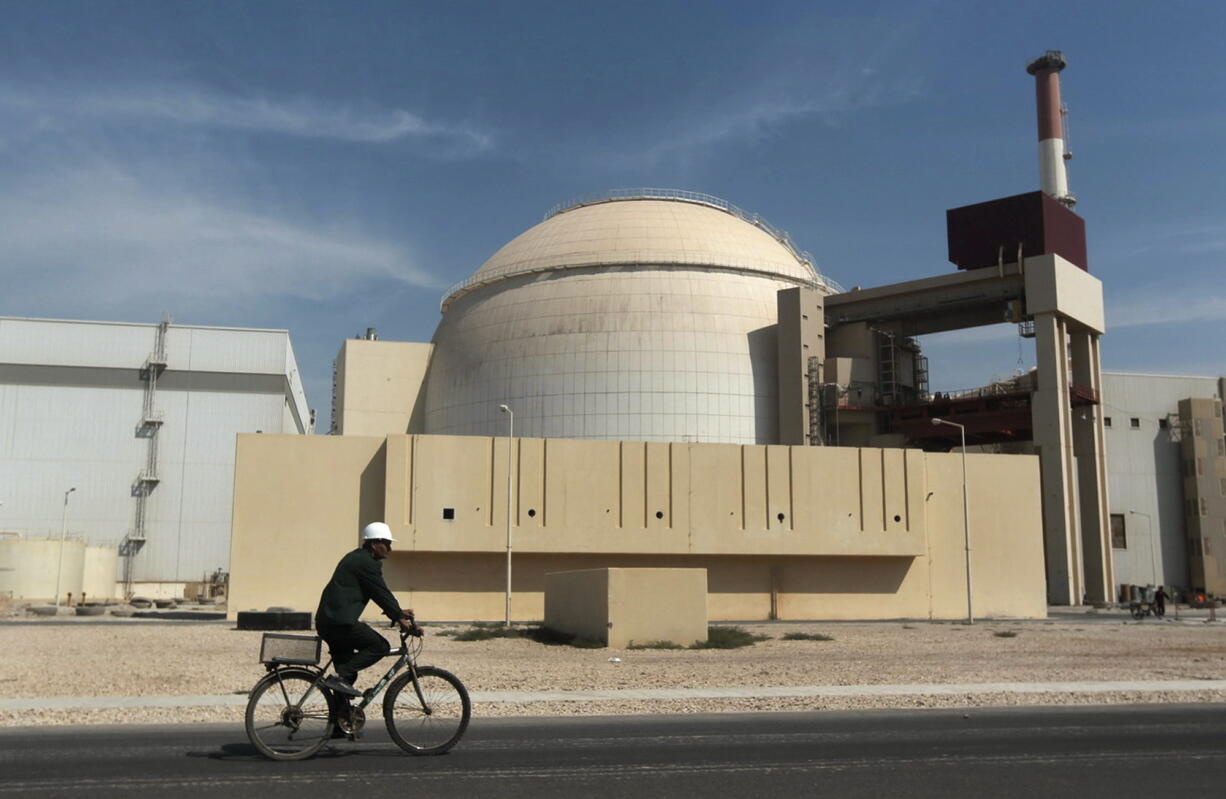 A worker rides a bicycle in front of the reactor building of the Bushehr nuclear power plant, just outside the southern city of Bushehr, Iran.