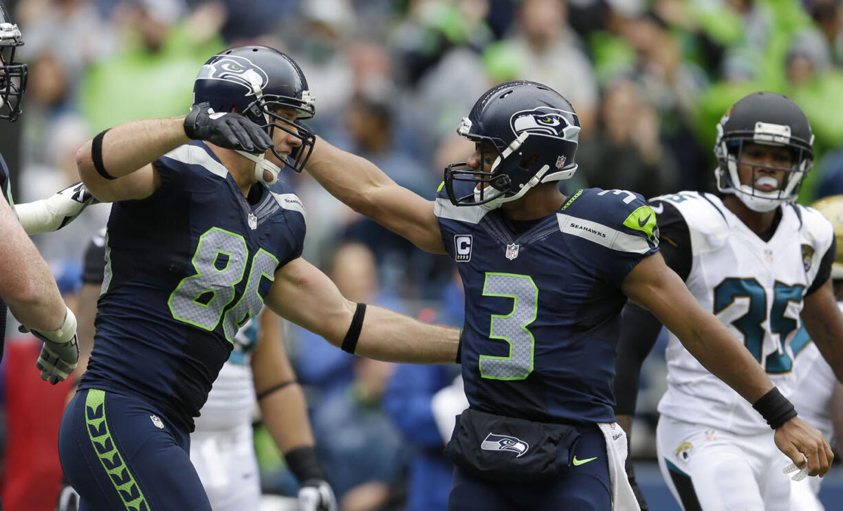 Seattle Seahawks quarterback Russell Wilson (3) congratulates Zach Miller on Miller's second touchdown reception against the Jacksonville Jaguars in the first half Sunday.